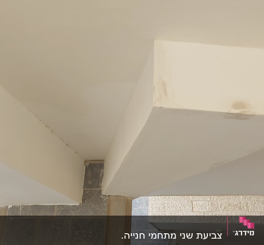 תקרה צבועה בלבן עם כתמי צבע קטנים